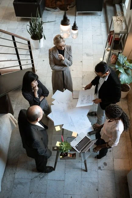 Un espace de travail contemporain où des mains analysent des données marketing sur un ordinateur portable et des documents papier.